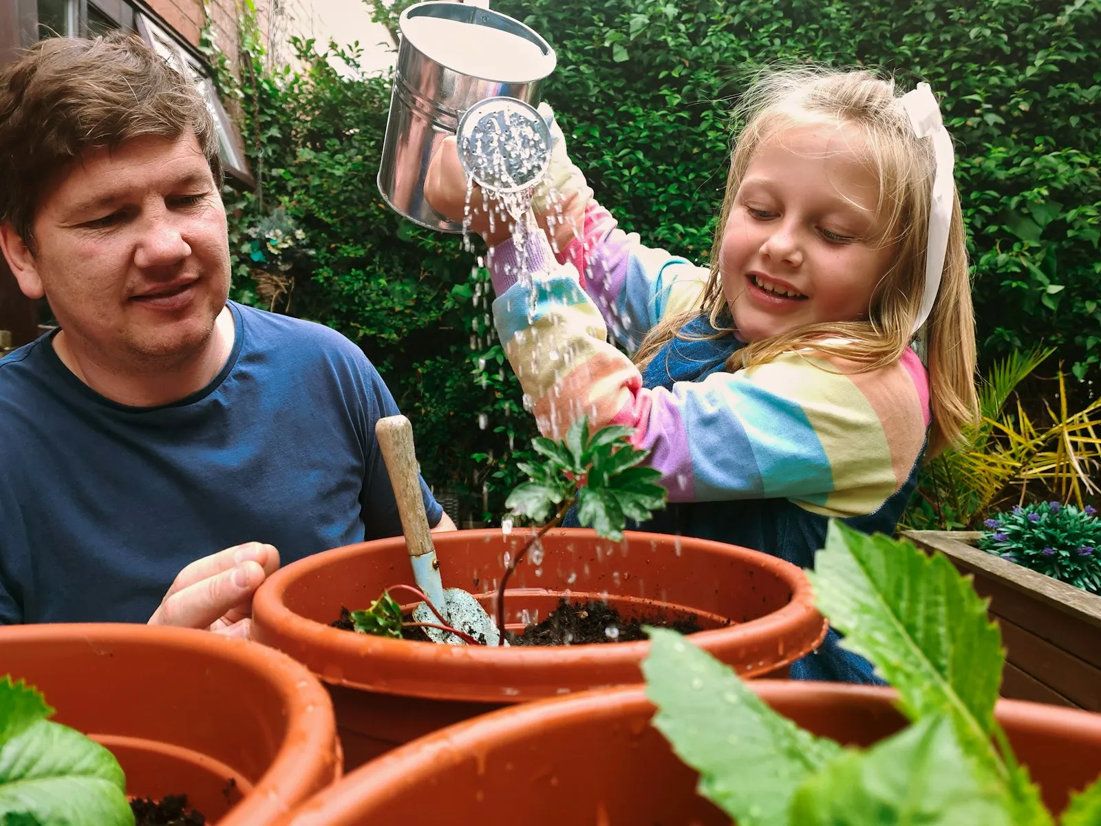 Kinderen leggen samen met een begeleider de beplanting aan